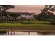 Backyard view showing a fenced-in dog park next to a scenic pond; great for recreation at 15148 Cuzcorro Ct, Nokomis, FL 34275