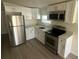 Modern kitchen with stainless steel appliances, white cabinets and new flooring at 15233 Omaha St, Hudson, FL 34667