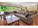 Spacious living room featuring a large comfortable sectional sofa, hardwood floors, and natural light streaming in from the windows at 1526 Ewing St, Nokomis, FL 34275