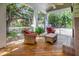 Inviting screened porch with comfortable seating, wood flooring, and views of the landscaped backyard and pool at 1526 Ewing St, Nokomis, FL 34275