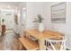 Bright dining area features wood table, bench seating, modern art and decor, and flows into entry hall at 17417 Haysack Ter, Lakewood Ranch, FL 34211