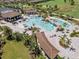 Aerial image of a sparkling community pool featuring a waterfall, lounge chairs, and tropical landscaping at 18114 Gawthrop Dr # 402, Bradenton, FL 34211