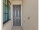 A gray front door with sidelight window, painted with modern hardware and a digital lock at 18114 Gawthrop Dr # 402, Bradenton, FL 34211