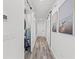 Bright hallway showcasing laundry area and wall art with modern sliding doors and stylish wood-look flooring at 18114 Gawthrop Dr # 402, Bradenton, FL 34211