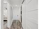 Hallway featuring wood-look flooring and white walls that provide access to the bedroom and utility spaces at 18114 Gawthrop Dr # 402, Bradenton, FL 34211