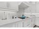 Detail of a modern kitchen counter, featuring white cabinets, quartz countertops, and stylish fixtures at 18114 Gawthrop Dr # 402, Bradenton, FL 34211