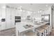 Modern kitchen with white cabinetry, a large island with bar stools, and stainless steel appliances at 18114 Gawthrop Dr # 402, Bradenton, FL 34211