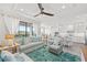 Bright living room featuring a coastal design with a ceiling fan and an open floor plan leading to the kitchen at 18114 Gawthrop Dr # 402, Bradenton, FL 34211