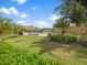 Beautifully landscaped community pool area with a rock waterfall feature, palm trees, and green lawns at 18114 Gawthrop Dr # 402, Bradenton, FL 34211