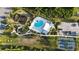 Aerial view of community pool, playground, parking, and tennis courts at 1824 Woodleaf Hammock Ct, Bradenton, FL 34211