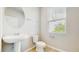 Powder room features a modern sink, round mirror, and window for natural light at 1824 Woodleaf Hammock Ct, Bradenton, FL 34211