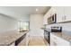 Modern kitchen with granite countertops, stainless steel appliances, and white cabinets at 1824 Woodleaf Hammock Ct, Bradenton, FL 34211