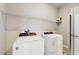 Spacious laundry room with modern washer and dryer and wire rack shelving at 1824 Woodleaf Hammock Ct, Bradenton, FL 34211