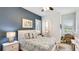 This nautical style bedroom has a calming blue accent wall, a queen bed, and lots of sunshine at 20359 Cristoforo Pl, Venice, FL 34293
