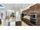 Gourmet kitchen with an island, granite countertops, stainless steel appliances, and plenty of cabinetry at 20359 Cristoforo Pl, Venice, FL 34293