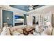 Elegant living room with a fireplace, stone accent wall, and an adjacent view into the office at 20359 Cristoforo Pl, Venice, FL 34293