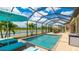 This is a screened-in pool with a view of the water and palm trees at 20359 Cristoforo Pl, Venice, FL 34293