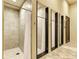Shower room featuring tiled walls, a tiled floor, individual shower stalls with curtains, and convenient changing spaces at 20359 Cristoforo Pl, Venice, FL 34293