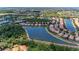 Expansive aerial view of a community featuring numerous homes surrounding a tranquil lake and lush greenery at 207 Winding River Trl, Bradenton, FL 34212