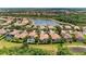 Aerial view of a lakefront community with homes featuring terra cotta roofs, mature landscaping, and private pools at 207 Winding River Trl, Bradenton, FL 34212