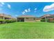 This large backyard features lush green grass and a serene view of the surrounding homes at 207 Winding River Trl, Bradenton, FL 34212