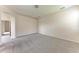Well-lit bedroom showcasing neutral walls and carpet, with an open doorway leading to another room at 207 Winding River Trl, Bradenton, FL 34212