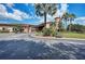 Community center entrance with lush landscaping, mature trees, and convenient golf cart parking at 207 Winding River Trl, Bradenton, FL 34212
