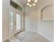 Bright foyer featuring tile floors, a decorative front door, and a modern chandelier at 207 Winding River Trl, Bradenton, FL 34212