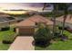 Inviting home featuring a brick driveway, well-manicured lawn, a terra cotta tile roof, and mature landscaping at 207 Winding River Trl, Bradenton, FL 34212
