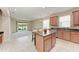 Spacious kitchen with a center island, wood cabinets, and tile flooring at 207 Winding River Trl, Bradenton, FL 34212