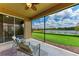 This screened-in lanai provides serene views of a lake and neighboring homes at 207 Winding River Trl, Bradenton, FL 34212