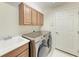 This laundry room features upper cabinets, a sink, and a front load washer and dryer at 207 Winding River Trl, Bradenton, FL 34212