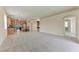 Open-concept living room with plush carpeting that leads to a modern kitchen at 207 Winding River Trl, Bradenton, FL 34212