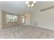 Bright living room with plush carpeting, neutral walls, and a large window for natural light at 207 Winding River Trl, Bradenton, FL 34212