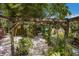 Charming backyard garden with a wooden pergola, lush greenery, and stone pathway at 2207 Hickory Ave, Sarasota, FL 34234