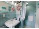 Retro-styled bathroom with blue tiling, decorative flamingo accent, and walk-in shower for a fun, vintage vibe at 2207 Hickory Ave, Sarasota, FL 34234