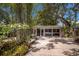 Driveway with lush landscaping and a garage with large windows at 2207 Hickory Ave, Sarasota, FL 34234