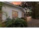 Exterior side view of home showing landscaping, a stone pathway, and lush foliage at 2207 Hickory Ave, Sarasota, FL 34234