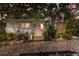 Charming home featuring a pink door, stone pathway, and beautiful tropical landscaping at 2207 Hickory Ave, Sarasota, FL 34234
