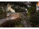 Charming home featuring mature trees, lush landscaping, and a welcoming, light-filled facade at 2207 Hickory Ave, Sarasota, FL 34234