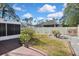 Backyard featuring a white fence, colorful garden features, green grass and a screened patio visible at 2371 Manheim Ave, North Port, FL 34286