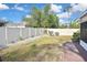A white fence surrounds the back yard which features green grass and decorative pebbles around garden features at 2371 Manheim Ave, North Port, FL 34286