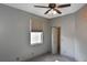 Neutral bedroom features a window with blinds, ceiling fan, and a door that leads to another room at 2371 Manheim Ave, North Port, FL 34286