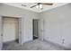 Neutral bedroom featuring a ceiling fan, closet, and a view into another room through an open door at 2371 Manheim Ave, North Port, FL 34286