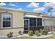 Lovely exterior view of the home featuring a screened-in porch, decorative rock and lush landscape at 2371 Manheim Ave, North Port, FL 34286