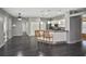 Open kitchen features white cabinets, stainless steel appliances, breakfast bar, and wood flooring at 2371 Manheim Ave, North Port, FL 34286