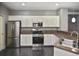 Open kitchen features white cabinets and stainless steel appliances, complete with breakfast bar at 2371 Manheim Ave, North Port, FL 34286