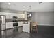 Open kitchen features white cabinets, stainless steel appliances, breakfast bar, and wood flooring at 2371 Manheim Ave, North Port, FL 34286