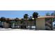 Inviting two-story building with balconies, beachfront access, and lush palm trees at 2412 N Gulf Dr # 119, Bradenton Beach, FL 34217