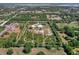 Aerial view showing property lines on acreage with a modern white home with a pond and surrounding greenery at 27510 67Th E Ave, Myakka City, FL 34251